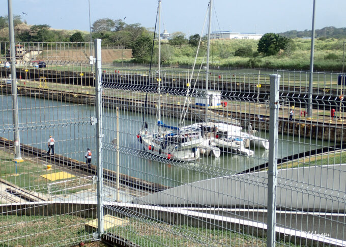 Monohull yacht and tri-hull catamaran in the Panama canal lock